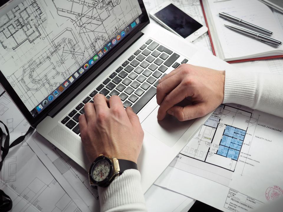 Reviewing plans and figures on a laptop